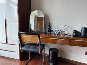 una silla sentada frente a un escritorio con espejo en Lexiangjia - Riverview Apartment en Hangzhou