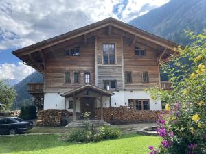 a large wooden house with mountains in the background at Grand Chalet in Flattach