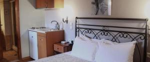 1 dormitorio con 1 cama con lavamanos y 1 cama sidx sidx sidx sidx en Guesthouse Νεδα, en Stemnitsa