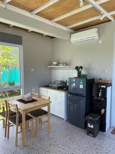 a kitchen with a table and a stove and a refrigerator at Monty’s Villa Umalas - 1 Bedroom in Kerobokan +1 photo