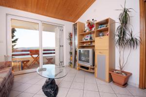 ein Wohnzimmer mit einem Glastisch und einem TV in der Unterkunft Apartments with a parking space Pisak, Omis - 5975 in Pisak