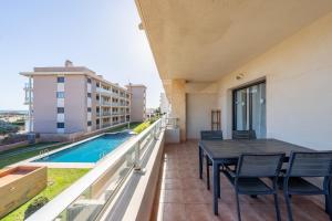 a balcony with a table and chairs and a swimming pool at Hauzify I Apartament Oliveres in Hospitalet de l'Infant