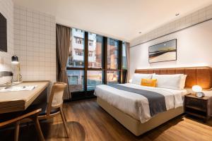 um quarto de hotel com uma cama e uma secretária em Dash Living on Hollywood em Hong Kong