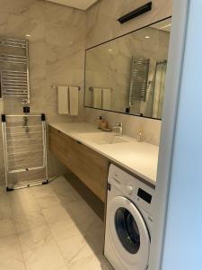 uma casa de banho com uma máquina de lavar roupa e um lavatório em Sea Breeze Apartments Lighthouse em Baku