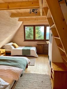 sypialnia z 2 łóżkami w drewnianym domku w obiekcie Chata na Soláni w mieście Vsetín