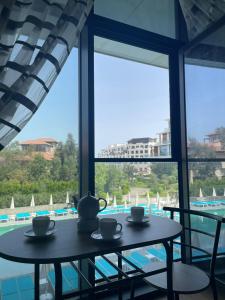 2 tafels in een kamer met uitzicht op een zwembad bij Sea Breeze Apartments Lighthouse in Baku