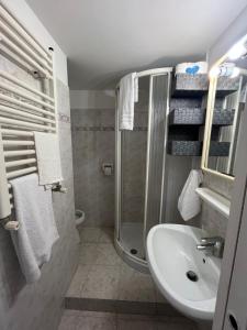 y baño con ducha y lavamanos. en Appartamento luminoso centro ladispoli, en Ladispoli