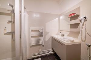 een witte badkamer met een wastafel en een douche bij Home - Joubert - Séjour à Auxerre in Auxerre