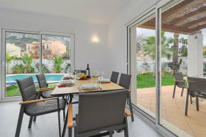 een eetkamer met een tafel en stoelen en een zwembad bij Limoncello in Denia