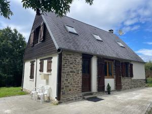 a small brick house with chairs in front of it at Nor50 - Pont Farcy - Chalet Papillon in Pontfarcy