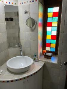 een badkamer met een wastafel en een kleurrijk raam bij Afames House - Beautiful Traditional House in Omodos