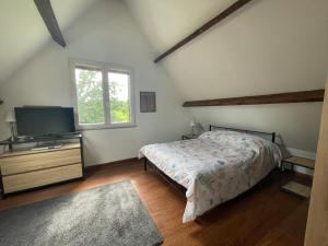 Schlafzimmer mit einem Bett und einem Flachbild-TV in der Unterkunft Nor50 - Pont Farcy - Chalet Papillon in Pontfarcy