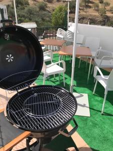 una parrilla en un patio con sillas y mesas en Casa Carrión Caminito del Rey, en Bermejo