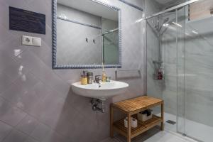 y baño con lavabo y ducha. en tuGuest Alhamar Apartment, en Granada