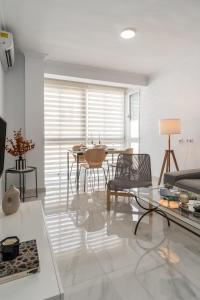 ein Wohnzimmer mit einem Tisch und Stühlen in der Unterkunft tuGuest Alhamar Apartment in Granada
