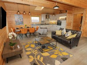 a living room with a couch and a table at Height End Farm Log Cabin in Bacup