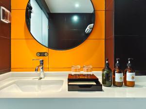 a bathroom sink with bottles of wine and a mirror at Nan'er Jieli Hotel - Chengdu Tianfu International Airport Branch in Jianyang