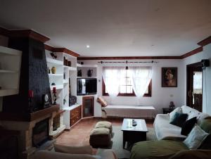 a living room with a couch and a fireplace at Espectacular Villa con piscina y vistas al valle in Cruz Santa