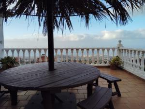 una mesa de madera en un balcón con vistas al océano en Espectacular Villa con piscina y vistas al valle en Cruz Santa