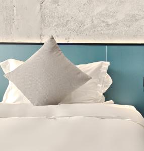1 cama con almohadas blancas y pared azul en Nan'er Jieli Hotel - Chengdu Tianfu International Airport Branch, en Jianyang