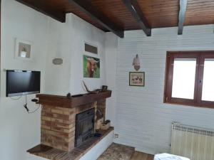 Una sala de estar con chimenea y TV de pantalla plana. en Le coucou, en Breitenau