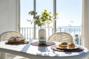 a table with a vase of flowers and a plate of food at Alea Rentals - Bell Racó in La Pineda