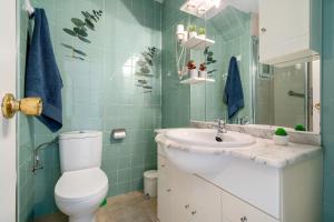 a bathroom with a white toilet and a sink at Alea Rentals - Bell Racó in La Pineda