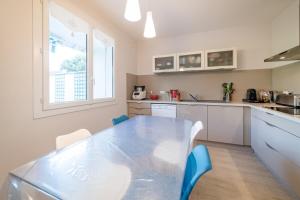 a kitchen with a glass table and blue chairs at Home - Hubert Fabureau - Séjour à Auxerre in Auxerre