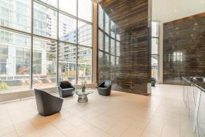 a lobby with two chairs and a table and windows at GLOBALSTAY. Elegant Downtown Apartments in Toronto