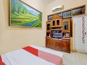 ein Schlafzimmer mit einem Bett und einem Wandgemälde in der Unterkunft OYO 92851 Homestay Borobudur Specpacker Syariah in Yogyakarta