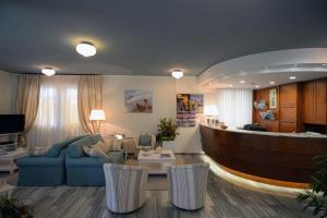 a living room with a blue couch and chairs at Hotel Giulio Cesare in Cinquale