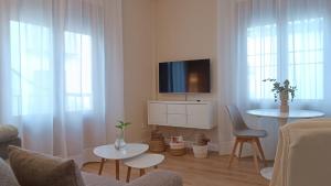 a living room with a tv and a table and chairs at Ciudad del encaje 2 in Almagro