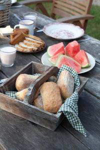 einen Holztisch mit Brotplatten und Wassermelonen-Sandwiches in der Unterkunft Bed and Breakfast Annen in Annen