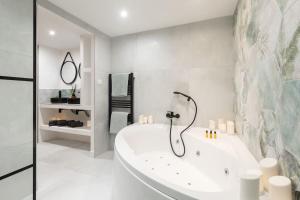 uma casa de banho branca com uma banheira e um chuveiro em Jungle Room de Charme em Marselha