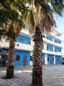 two palm trees in front of a building at Hotel Rozafa Velipoje in Velipojë