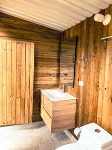 baño de madera con lavabo y aseo en La Chagra VIP, en Villavicencio