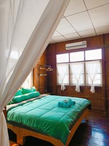 a bedroom with a large green bed in a room at PAI BAAN Homestay ปายบ้าน โฮมสเตย์ ถนนคนเดินปาย in Pai