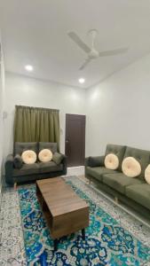 セパンにあるBabah Homestay KLIAのソファ2つとコーヒーテーブルのあるリビングルーム