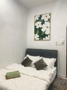 セパンにあるBabah Homestay KLIAの白いシーツと壁に絵が描かれたベッド