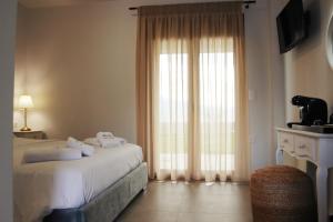ナフパクトスにあるSanta Domenica Nafpaktos - Rooms and Apartments by the Seaのベッドと大きな窓があるホテルの部屋