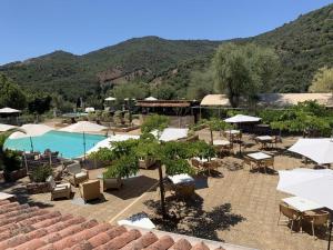 een uitzicht op een resort met een zwembad en tafels en stoelen bij Domaine de l'Oriu in Serriera