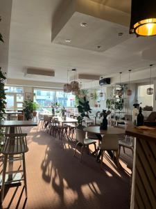 a restaurant with tables and chairs and plants at Kesta Apartmán in Martin