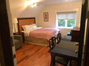 a bedroom with a bed and a chair and a window at Broadway guest house in Vancouver