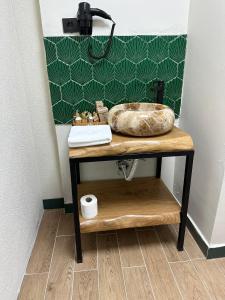 a bathroom with a sink on a table with a mirror at Kingway Suite in Nusratlı