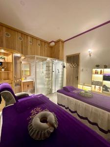 een slaapkamer met 2 bedden met paarse lakens bij Minh Hoàng Hotel & Spa - Phan Thiết in Ấp Bình Hưng