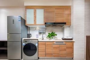 a kitchen with a refrigerator and a dishwasher at Orange Apartments in Chengdu