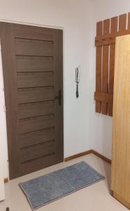 - une porte en bois dans une chambre avec un tapis dans l'établissement Hostel Reja 54A, à Suwałki