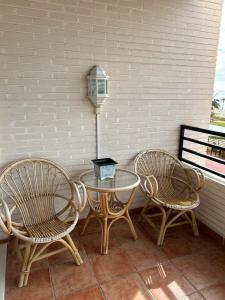 ビリャホヨサにあるPlaya Paraiso 31Aのテーブルと椅子2脚、パティオ(ランプ付)