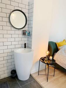 a bathroom with a sink and a mirror and a table at Country House - Garden - Private access to the Loir in La Chartre-sur-le-Loir