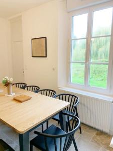 a dining room with a wooden table and chairs at Country House - Garden - Private access to the Loir in La Chartre-sur-le-Loir